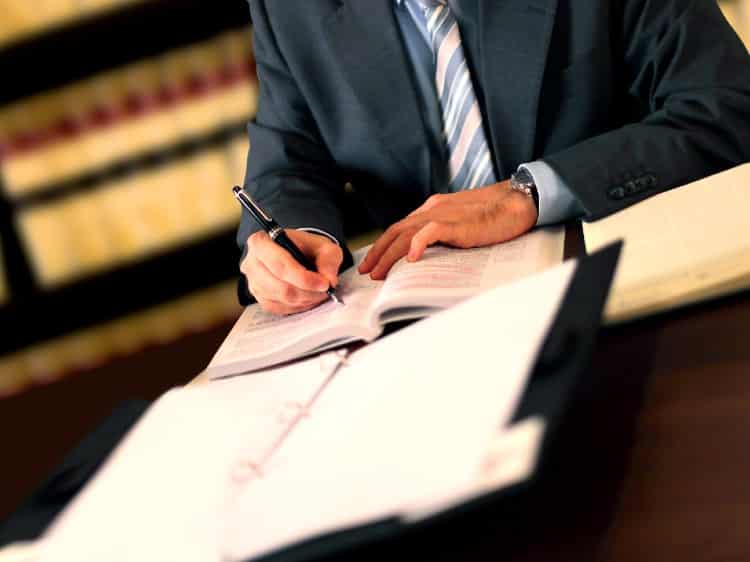 Stabbing Injury Lawyer At Table With Personal Injury Books