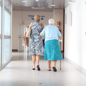 helping elderly walk in hallway