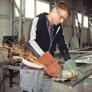 workshop employee using angle grinder